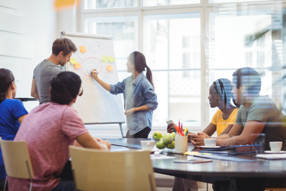 business-executives-discussing-with-their-colleagues-whiteboa (1)
